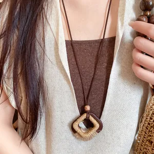 Detailopname van een Boheemse retro ketting met hout en geweven hennep hanger.