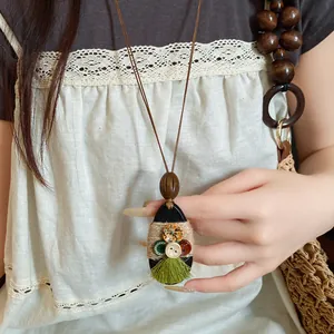 Close-up van bohemian hanger ketting met knopen, hennep touw en groene kwast details.