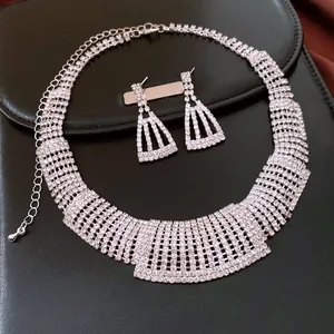 Detailed view of luxury rhinestone trapezoidal necklace and matching earrings on black leather