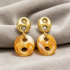 Close-up of French vintage hollow resin drop earrings with marbled amber texture design.