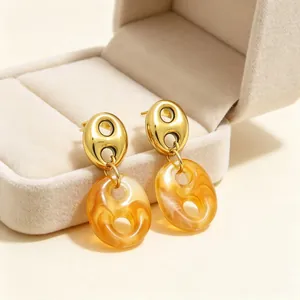 Close-up of French vintage gold-tone pig nose earrings with amber resin pendant