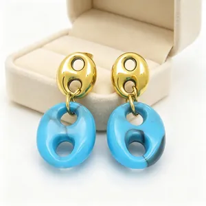 Detailed view of French retro pig nose earrings in gold and marbled blue resin jewelry.