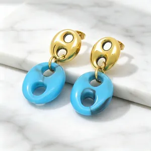 Macro view of French vintage gold-tone and blue resin pig nose textured drop earrings