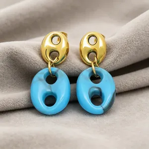 Close-up detail of French vintage resin pig nose pendant earrings with blue marbling effect