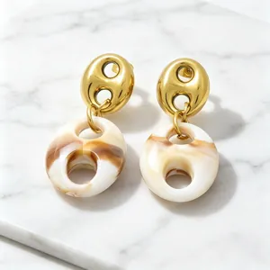 Detail view of French vintage pig nose earrings with gold hollow and resin marble pendants