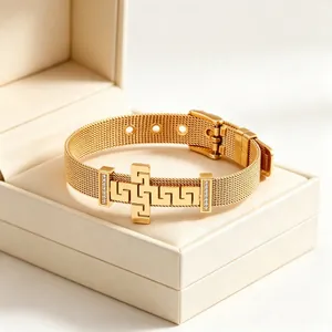 Close-up of gold stainless steel mesh bracelet with Greek key cross and pavé diamonds