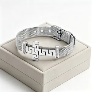 Detailed view of silver stainless steel mesh bracelet featuring a meander pattern cross.