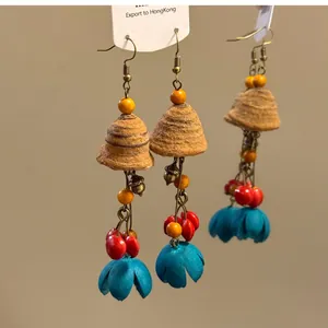 Boucles d'oreilles ethniques avec graines naturelles, perles et pétales bleus.