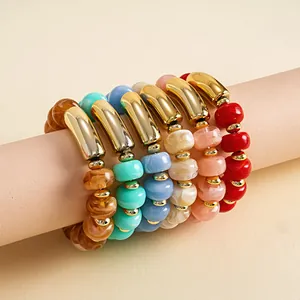 Detailaufnahme bunter elastischer Acrylperlen-Armbänder mit goldenen Akzenten.
