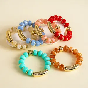 Nahaufnahme von bunten Acrylperlen-Armbändern mit goldenen Akzenten in vielen Farben