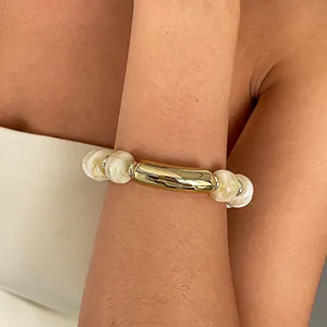 Detailansicht eines elastischen Acryl-Perlenarmbands mit goldenem Rohr-Element