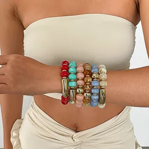 Vibrante gestapelte bunte elastische Armbänder aus Acrylperlen am Handgelenk eines Models