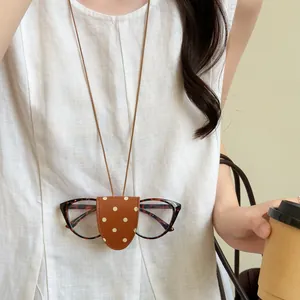 Close-up of leather polka dot magnetic glasses holder necklace worn as accessory