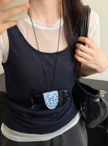 Close-up detail showing a leopard print magnetic sunglasses clip worn as a fashion necklace