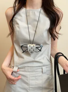 Detail of a portable leather magnetic glasses clip necklace with black polka dot pattern.