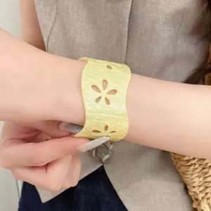 Minimalist yellow acrylic open bangle featuring elegant floral cutouts and wave edges
