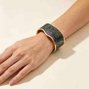 Macro view of gold-plated V-shaped bangle with colorful marbled oil painting texture