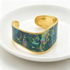 Macro view of colorful oil painting texture on wide gold V-shaped cuff bracelet.