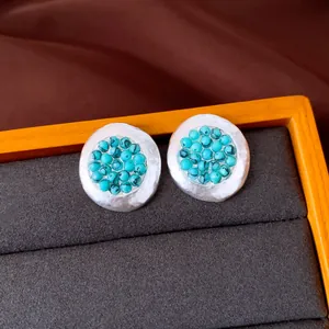 Detalle macro de pendientes plisados plateados con cuentas turquesas de estilo retro