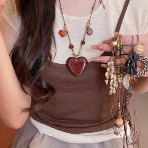 Close-up of vintage bohemian heart pendant necklace worn by a model