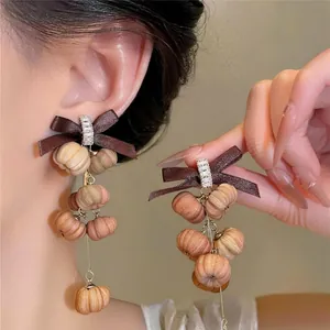 Elegant bohemian zircon ribbon bow drop earrings with textured brown pumpkin beads