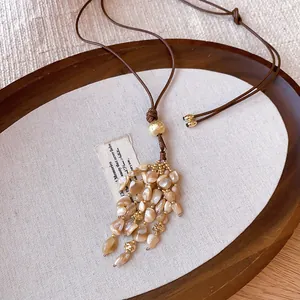 Close-up of retro Bohemian tassel necklace with polished stones and golden beads.