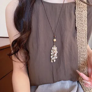 Vintage Bohemian tassel necklace with tiger eye stones styled on a simple brown top