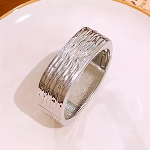 Breiter quadratischer Silberarmreif mit glänzender Faltenstruktur und modernem Design