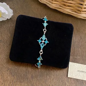 Elegante zilveren armband met blauwe ruitkristallen op een zwart fluwelen pad
