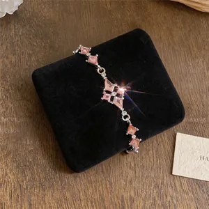 Detailweergave van een elegant roze strass-armband op luxe zwart fluweel