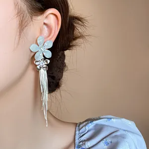 Détail de boucles d'oreilles élégantes en argent avec fleurs en zircone et pampilles