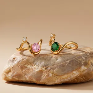 Macro view of geometric gold stainless steel rings with pink and green cubic zirconia