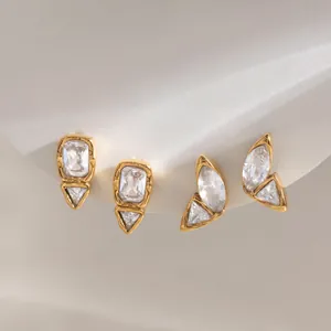 Makrodetail von unregelmäßigen Ohrsteckern aus 18k vergoldetem Edelstahl mit Zirkonia-Steinen.