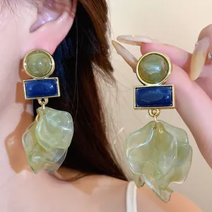 Close-up view of elegant geometric acrylic petal statement earrings worn on an ear