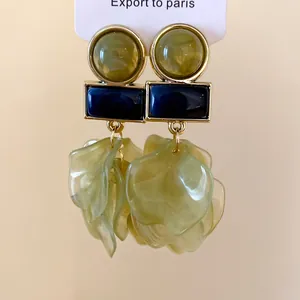 Detail view of unique acrylic petal drop earrings with gold-toned geometric accents