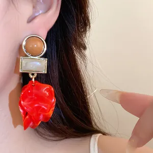 Large red acrylic petal statement earrings featuring round and square geometric elements