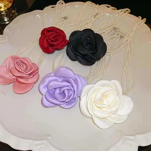 Auswahl an bunten Stoff-Rosen-Halsketten mit eleganten mehrlagigen weißen Kunstperlen
