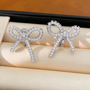 Detaillierte Makroansicht eleganter silberner Schleifen-Ohrclips mit weißen Zirkonia