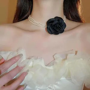 Detail der mehrlagigen Perlen-Choker-Halskette mit eleganter großer schwarzer Stoffrose