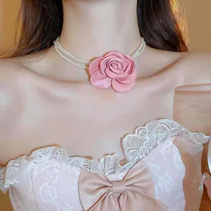Detailansicht einer eleganten mehrsträngigen Perlenkette mit großer rosa Stoffrose