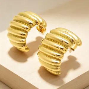 Detailed macro view of 18K gold plated stainless steel pleated croissant hoop earrings