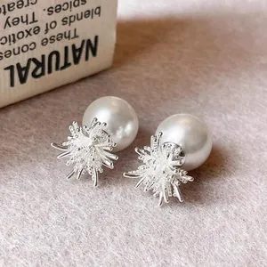 Vue macro de boucles d'oreilles perles en argent de style français avec motif étoilé.
