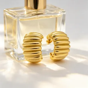 Close-up detail of 18K gold-plated stainless steel ribbed earrings with pleated texture