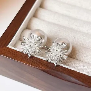 Vue détaillée de boucles d'oreilles perles argentées élégantes dans un écrin en bois chic
