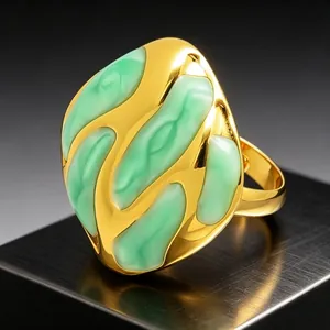 Vista detallada de un anillo chapado en oro con patrón fluido de esmalte verde abstracto