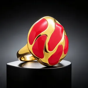 Primer plano detallado del patrón abstracto de esmalte rojo en el anillo de oro