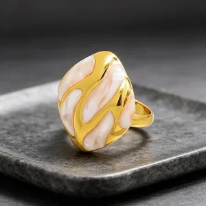 Detalle macro de anillo abstracto de esmalte con patrón fluido y chapado en oro