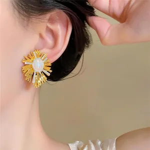 Detailansicht eines Sonnenstrahl-Ohrsteckers mit ovaler Perle und 18 Karat Goldbeschichtung