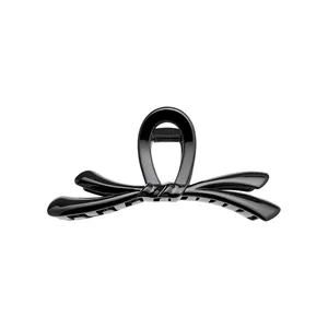 Pinza para el cabello con forma de lazo negro brillante y agarre fuerte.