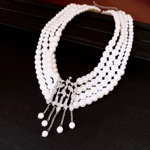 Détail d'un collier de perles multicouches avec un pendentif géométrique incrusté de cristaux